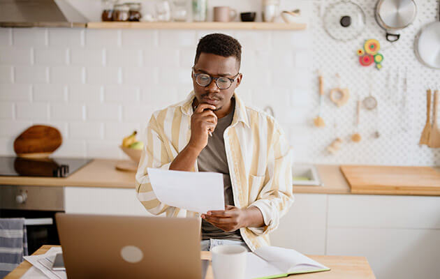 Large Young Man Looking At Paper And Thinking