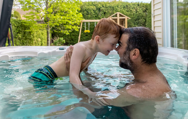 father son playing in hot tub large