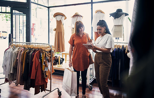 Large Female Shop Owner Talking And Helping Customer