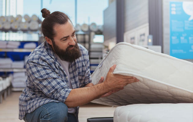 man evaluating mattress in store large