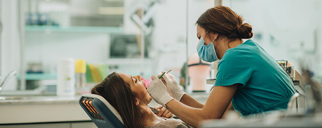 Medium Dentist Taking Care Of Client Teeth In Clinic