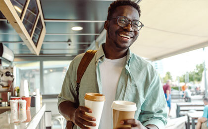 man with glasses smiling laughing with coffee small