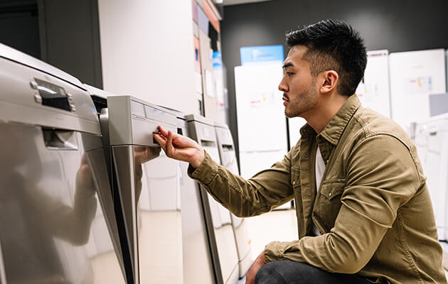 Large Men Looking And Shopping For Dishwasher In Store