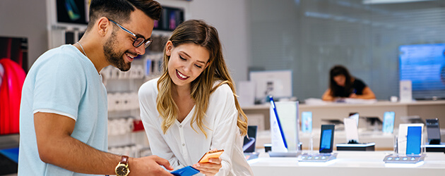 Medium Couple Shopping For New Electronics Device In Store