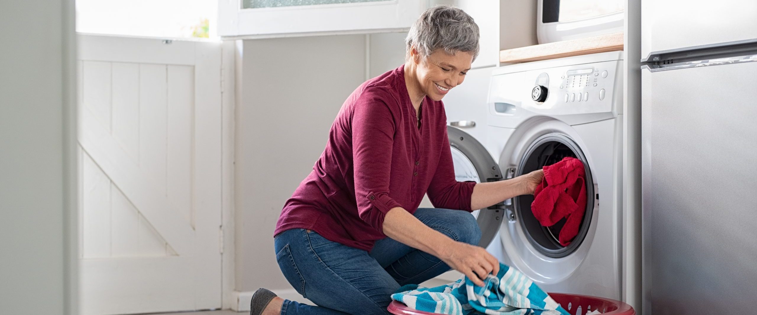 Woman loading clothes in washing machine