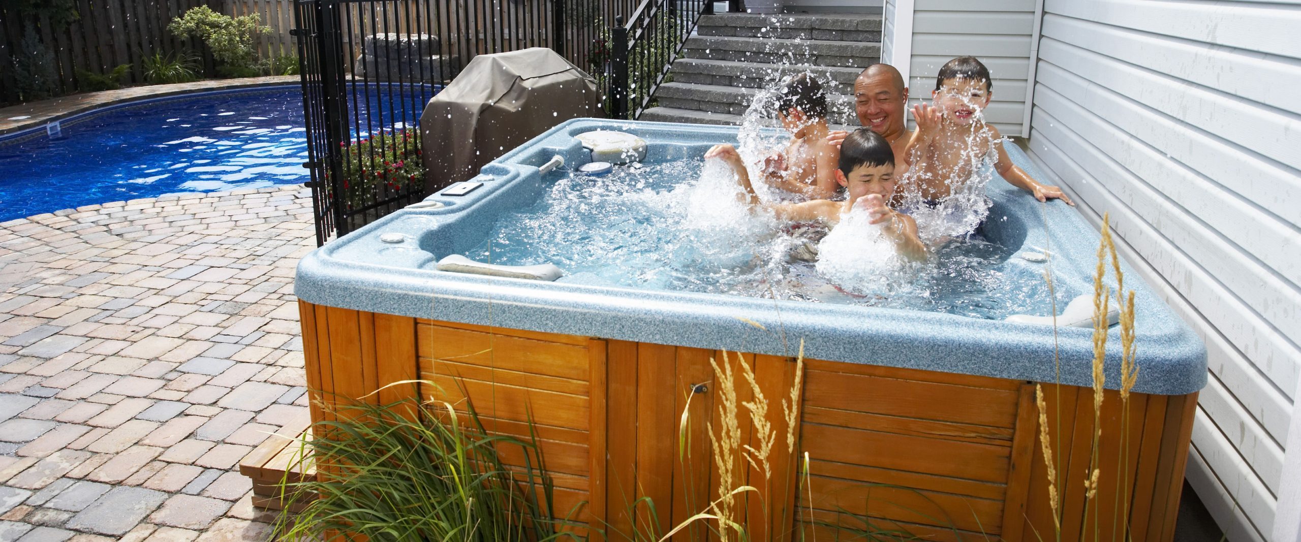 dad sons splashing hot tub hero