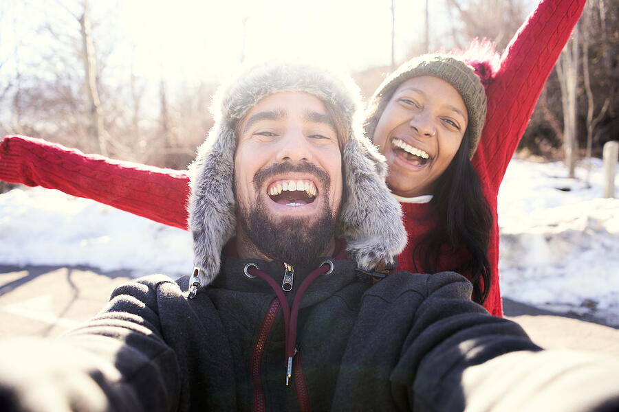 Happy couple taking a selfie in the snow.