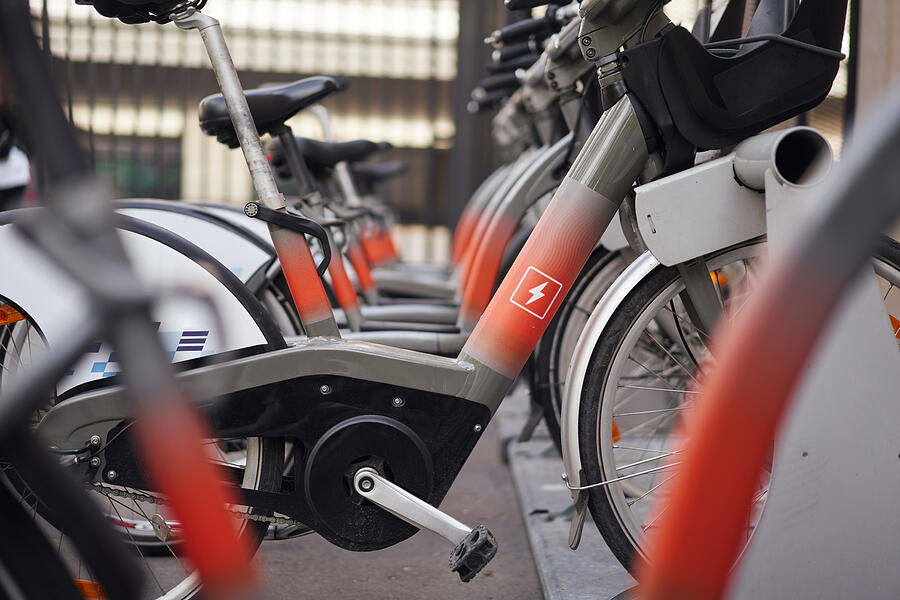 A row of electric bikes parked next to each other.