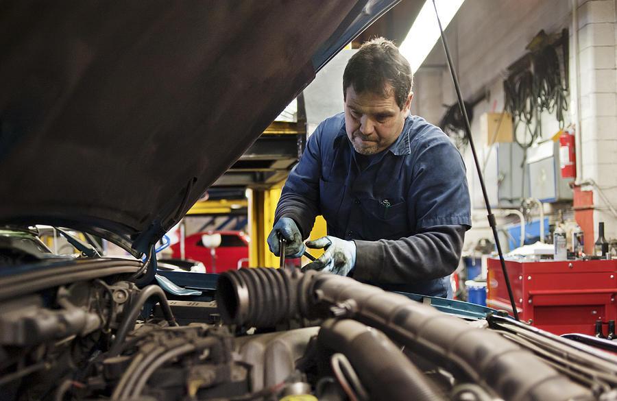 Mechanic working under the hood of a vehicle.