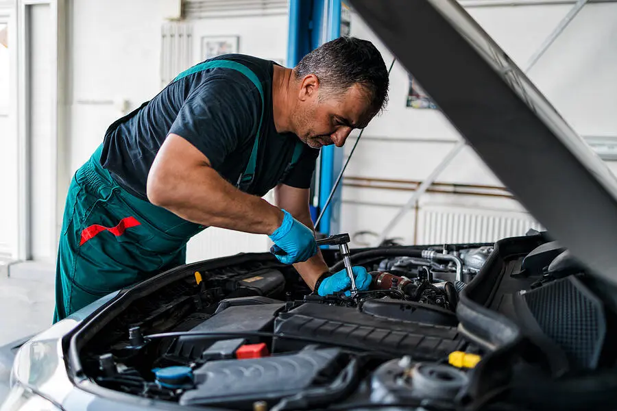 A mechanic doing auto repairs on an engine