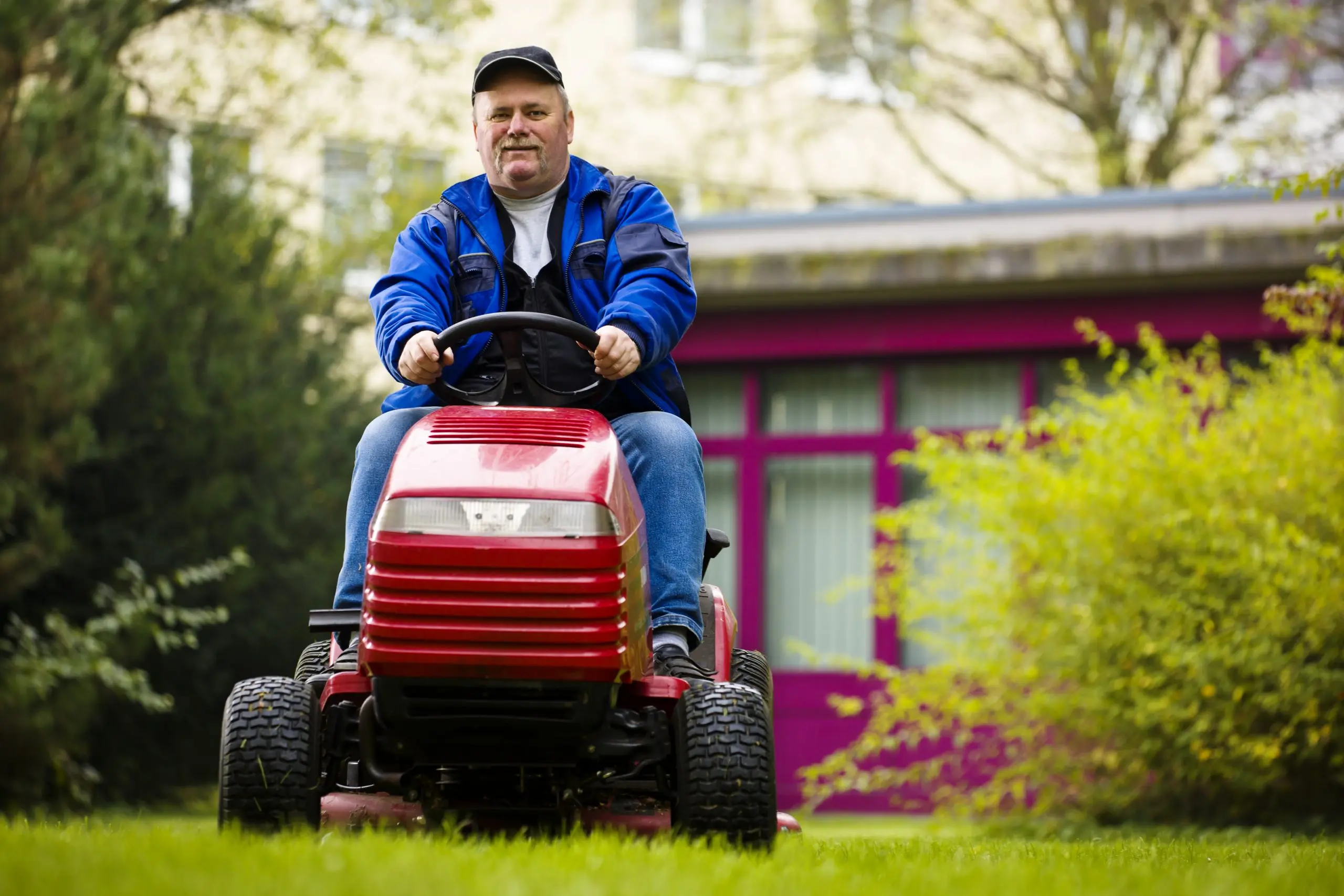 man riding zero turn lawn mower hero
